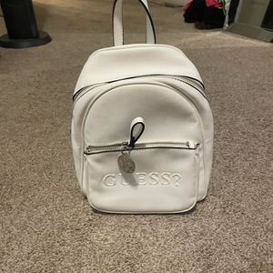 White guess backpack. Hand for size reference
